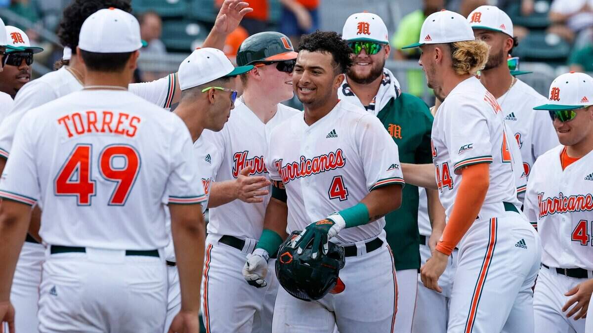 Miami Hurricanes catcher Maxwell Romero Jr. (4) is congratulated by teammates after hitting a three run home run during the third inning of an NCAA baseball game against the Towson Tigers in Alex Rodriguez Park at Mark Light Field on Sunday, February 20, 2022 in Coral Gables.