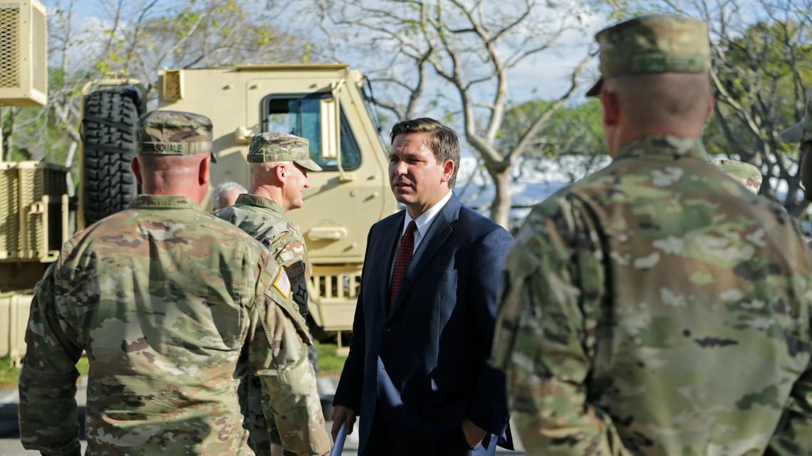Florida Gov. Ron DeSantis talks to members from the Florida National Guard after the press conference at the Broward County mobile testing at CB Smith Park in Pembroke Pines on Thursday, March 19, 2020.