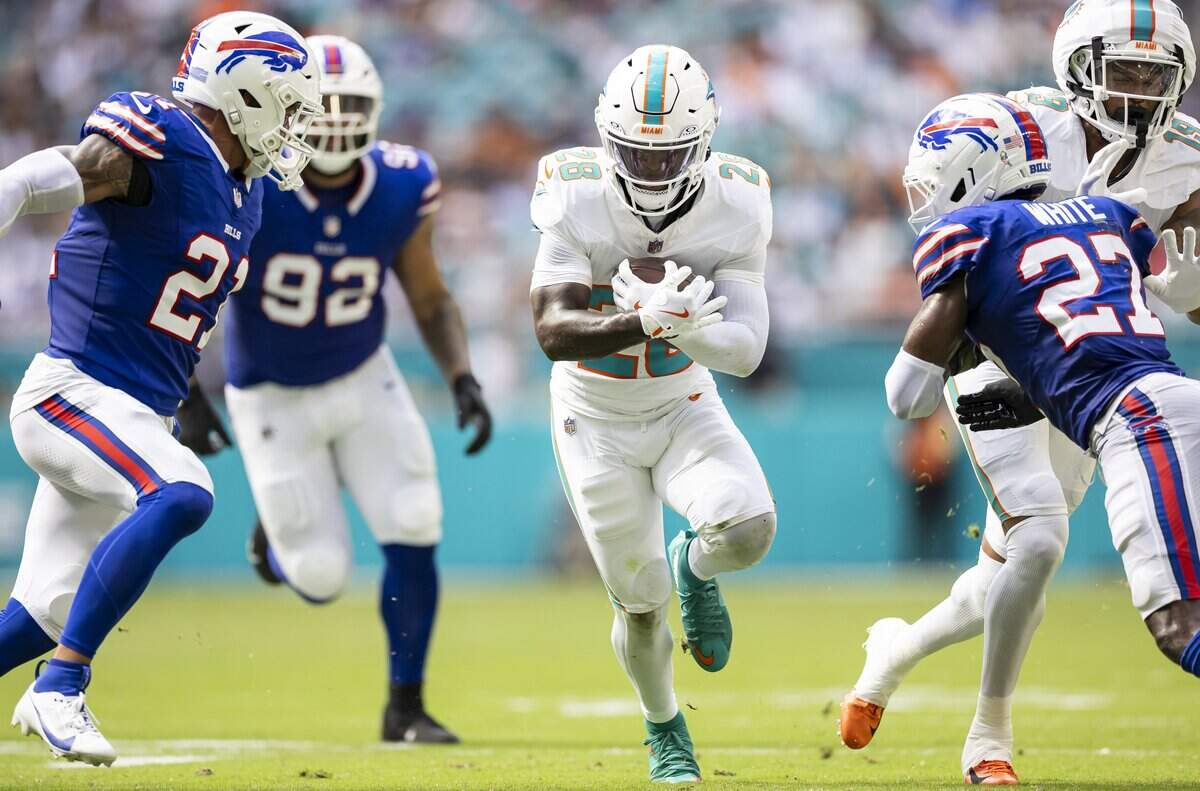 Miami Dolphins running back De'Von Achane (28) is tackled by Buffalo Bills safety Jordan Poyer (21) and cornerback Tre'Davious White (27) in the first half of their NFL game at Hard Rock Stadium on Sunday, Nov. 9, 2025, in Miami Gardens, Fla.