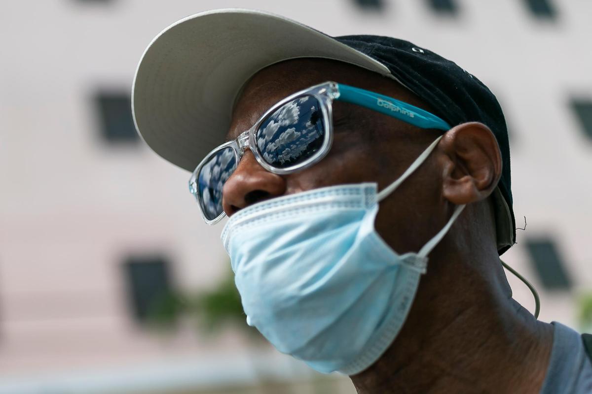 Curtis Larue Johnson, 61, walks with his bike near the Miami Rescue Mission Clinic as concerns over COVID-19 continue to spread through South Florida.