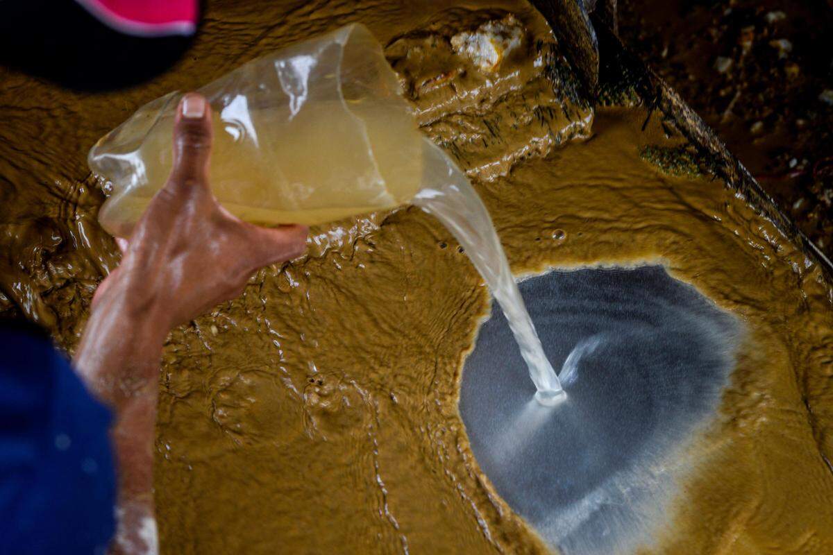 Un trabajador mezcla agua, oro y mercurio en una mina en El Callao, en el estado Bolívar. A pesar de los peligros del mercurio para la salud, los venezolanos se lanzan a trabajar en las minas en medio de una economía colapsada.