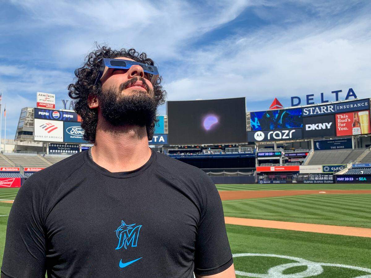 El relevista de los Marlins Andrew Nardi observa el eclipse solar en el Yankee Stadium en Nueva York, el 8 de abril de 2024.