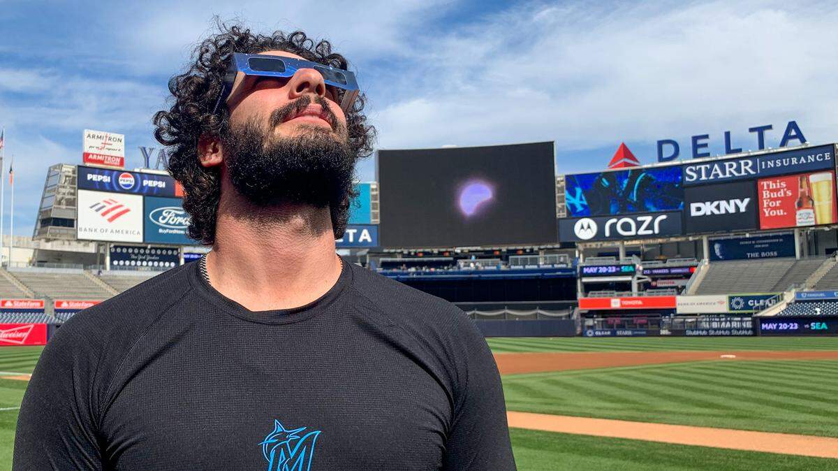 Miami Marlins reliever Andrew Nardi looks up at the sky to watch the solar eclipse on Monday, April 8, 2024, from the field at Yankee Stadium.