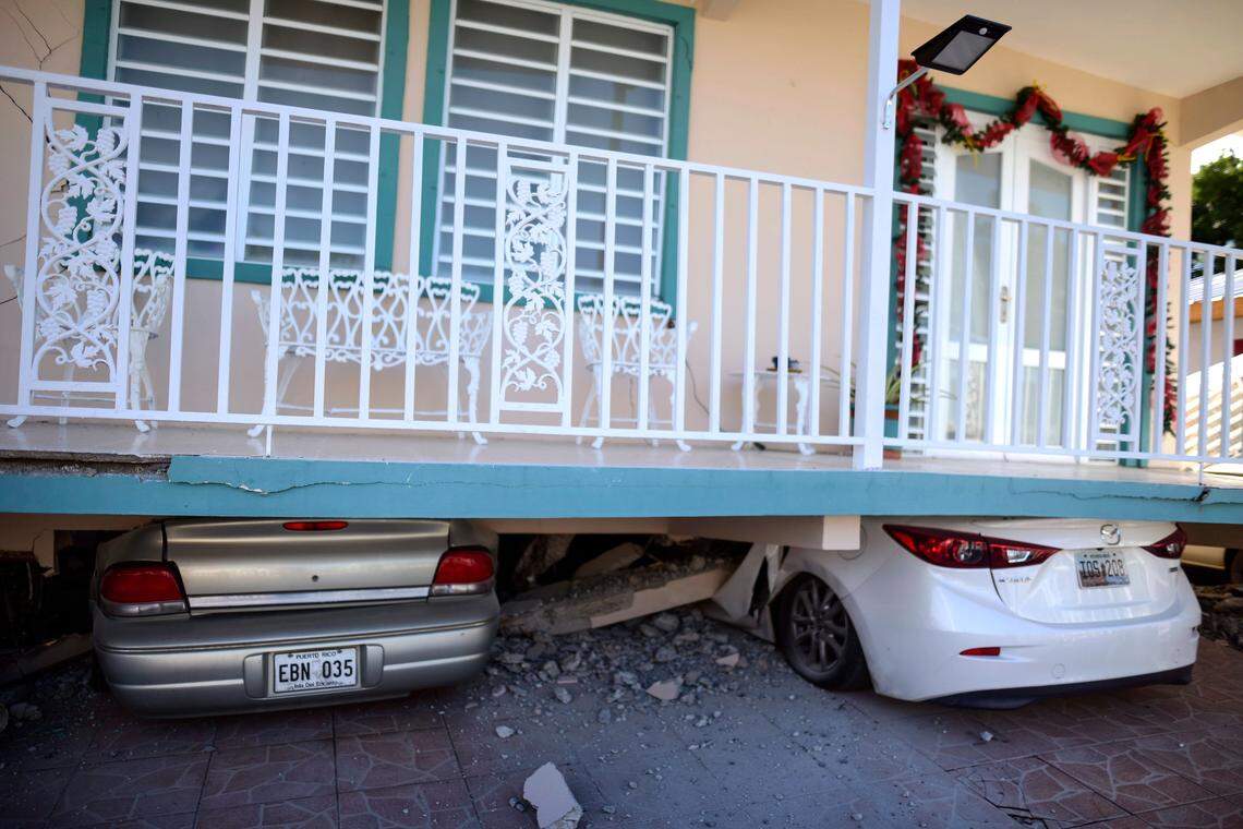 Cars are crushed under a home that collapsed after an earthquake hit Guanica, Puerto Rico, on Monday, Jan. 6, 2020.