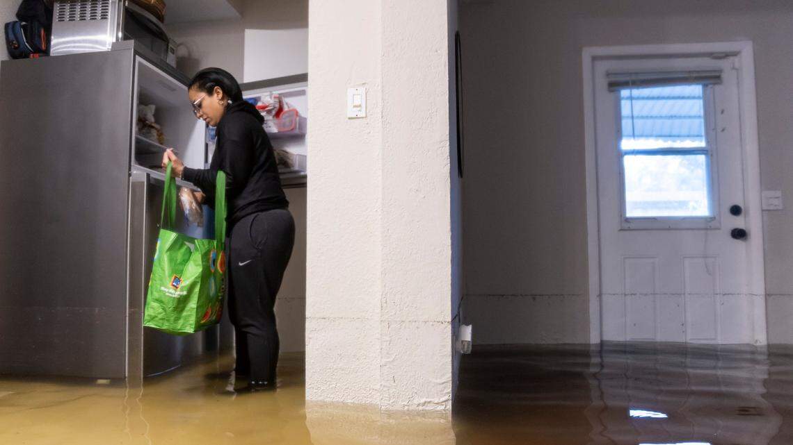 Denis Mendez, 32, packs food while inside their partially submerged home in the Edgewood neighborhood on Thursday, April 13, 2023, in Fort Lauderdale, Fla. A torrential downpour severely flooded streets partially submerging houses and cars across South Florida.