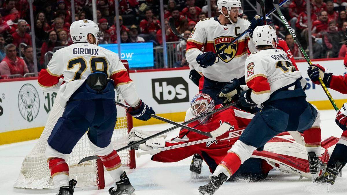 Washington Capitals goaltender Ilya Samsonov (30) reaches for the puck with Florida Panthers right wing Claude Giroux (28), centers Aleksander Barkov (16) and Sam Reinhart (13) around him during the second period of Game 4 in the first-round of the NHL Stanley Cup hockey playoffs, Monday, May 9, 2022, in Washington. (AP Photo/Alex Brandon)