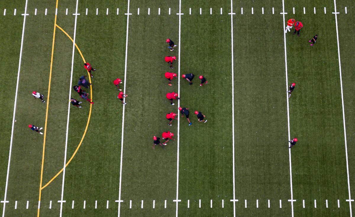 Miami Edison football players run drills during a preseason practice at their school’s field in Miami’s Little Haiti neighborhood on Tuesday, August 3, 2021.