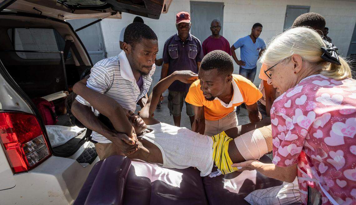 A man is lifted into the back of a van at Centre de Sante Lumiere hospital in Les Cayes, Haiti, on Aug. 16, 2021. He was being taken to the airport so the U.S. Coast Guard could fly him to Port-au-Prince.