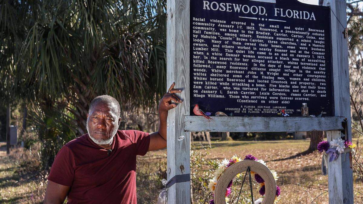 The Florida Department of Education on Wednesday, July 19, 2023, approved new standards for teaching Black history to K-12 students in Florida public schools, despite criticism from teachers and Democratic lawmakers that the curriculum was incomplete. In this photo, retired FIU professor Marvin Dunn, seen on Feb. 8, 2021, leans on a sign erected by the state of Florida in 2004 along Highway 24 in memory of Rosewood, a majority-Black hamlet west of Gainesville burned to the ground in 1923 after a white woman claimed she’d been attacked in her home by a Black man.