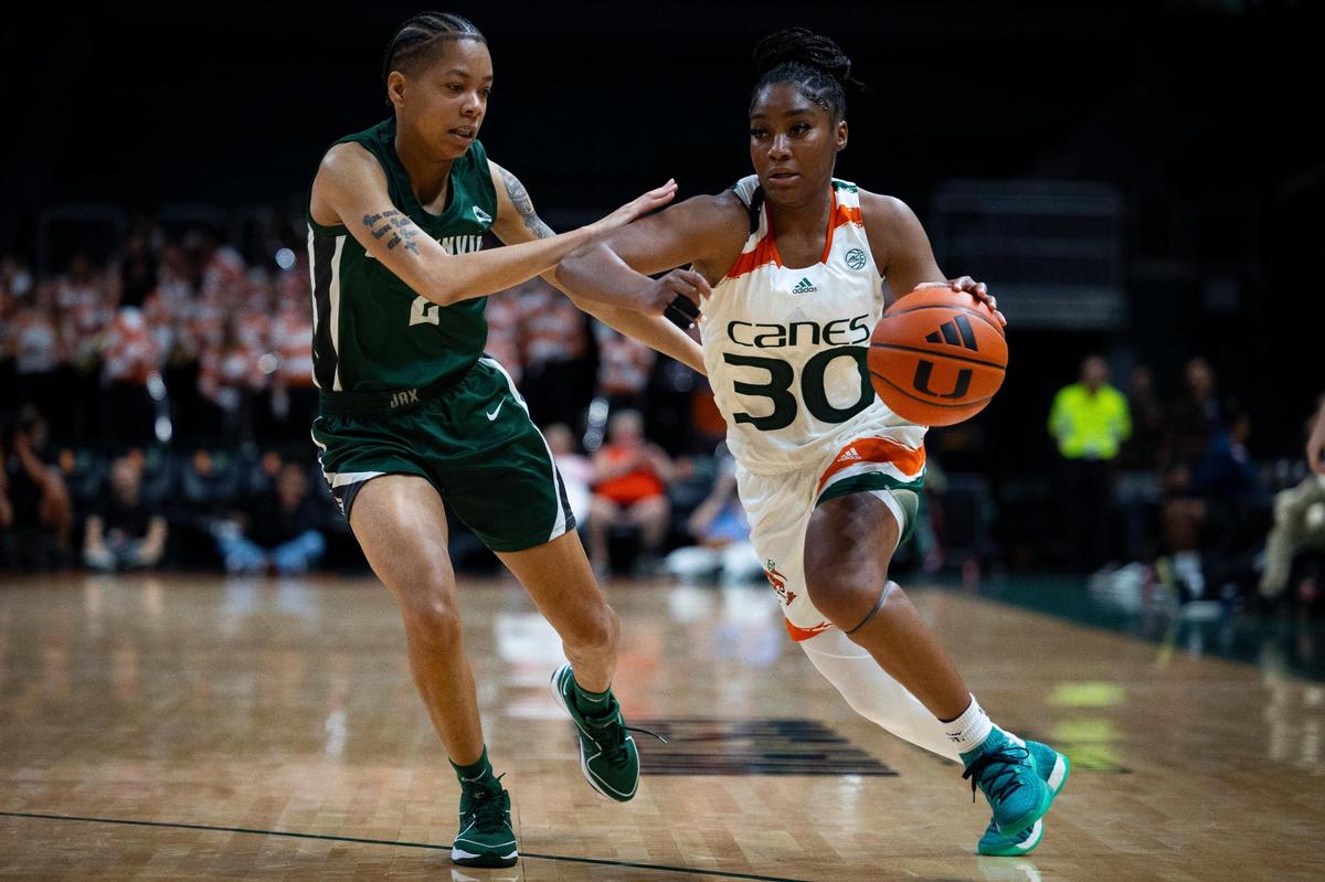 Miami Hurricanes Shayeann Day-Wilson (30) dribbles around Jacksonville’s Kyshonna Brown (2) during the fourth quarter of the University of Miami home opener on Thursday, Nov. 9, 2023, at the Watsco Center in Coral Gables.