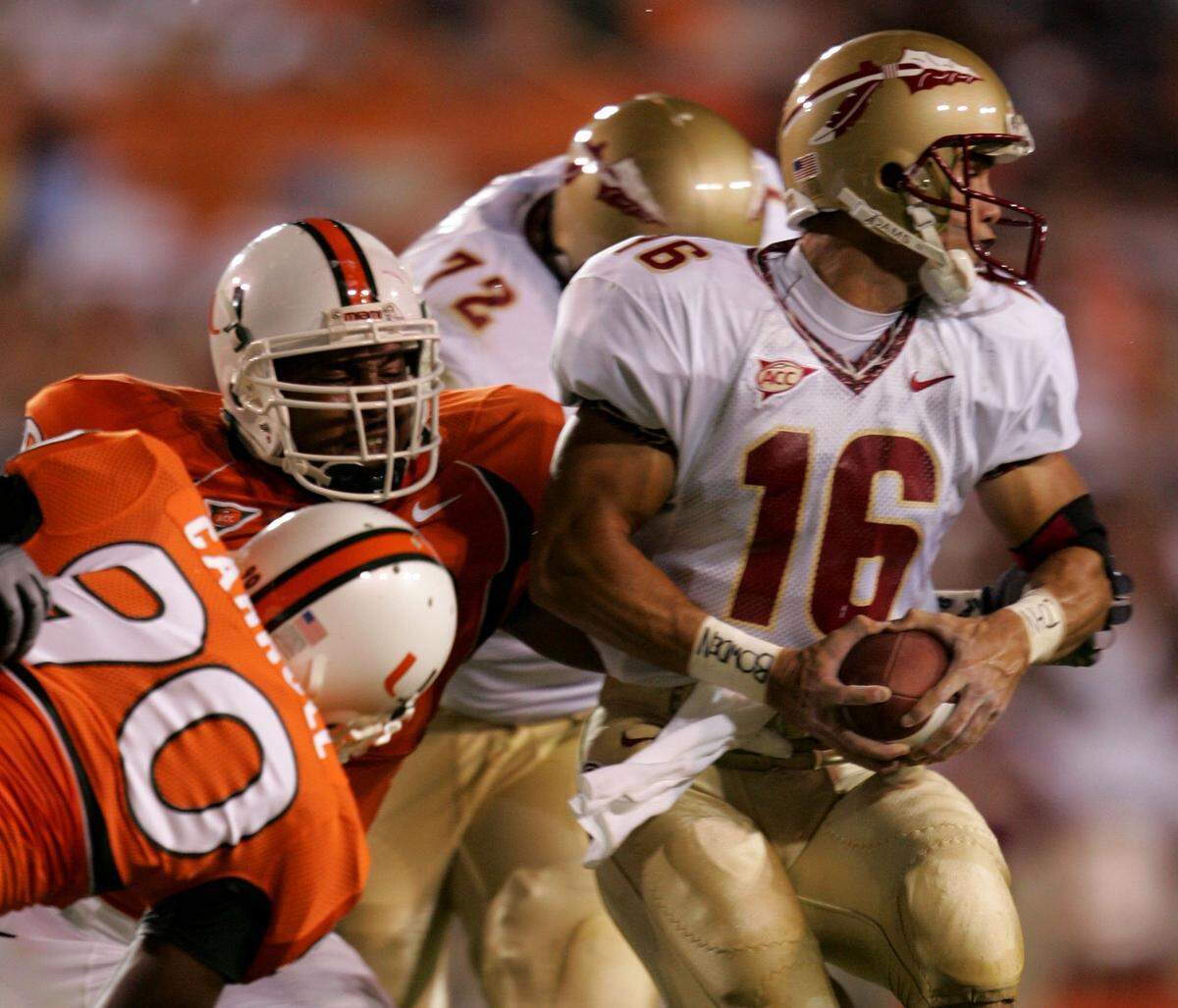 In 2004 at the Orange Bowl, UM's Thomas Carroll, left, and Kareem Brown, center, put pressure on FSU QB Chris Rix. UM won 16-10 in overtime during their season opener.