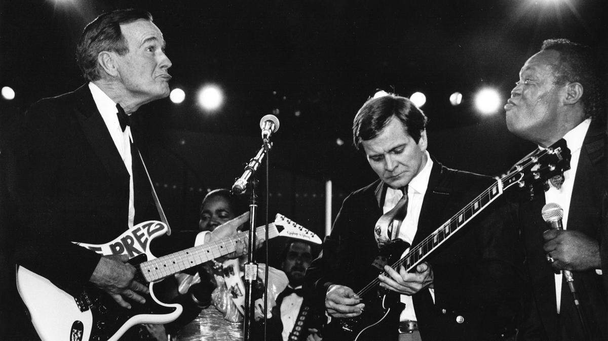 After receiving “The Prez” guitar - a present - from Sam Moore (right) of the famed Sam and Dave soul duo, President George H.W. Bush, left, plays the instrument with Republican National Committee Chairman Lee Atwater on Jan. 21, 1989. Joyce Moore, Sam’s wife, co-produced the inaugural event at The Washington Convention Center.