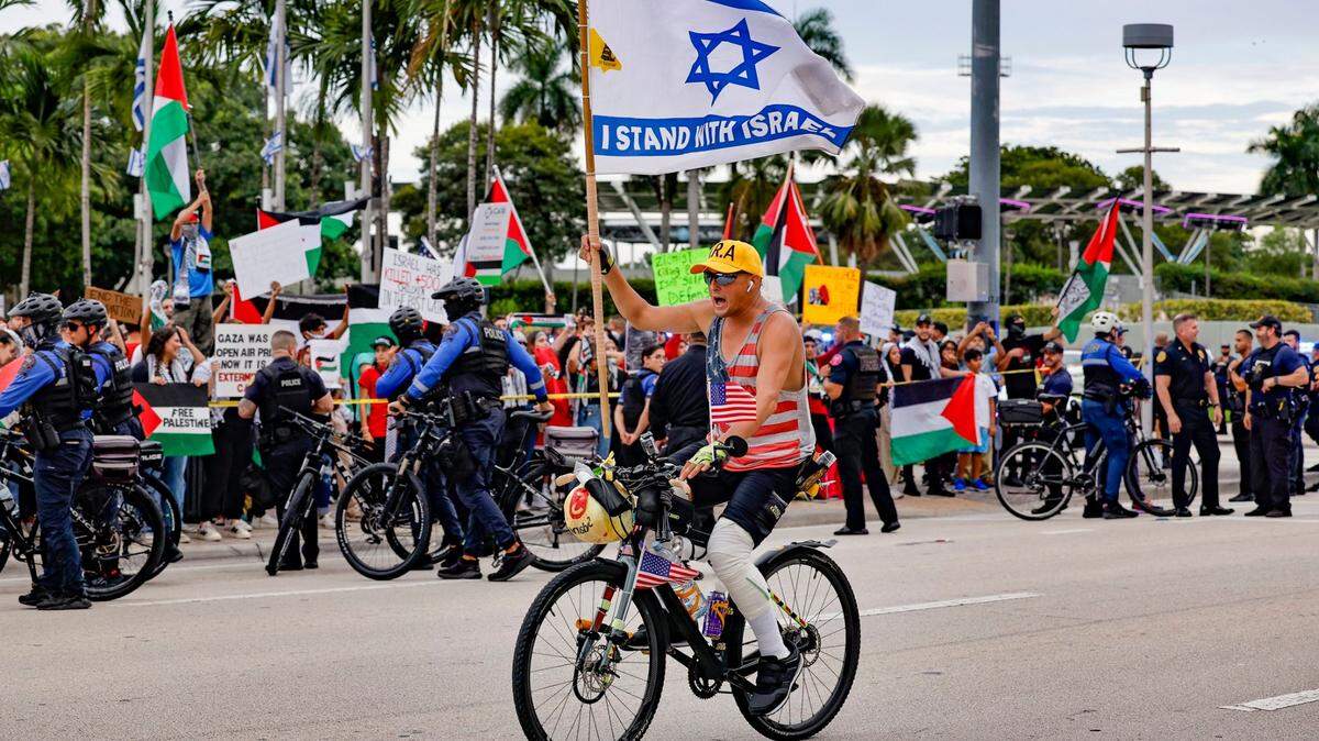 UN MANIFESTANTE proisraelí anda en bicicleta por Biscayne Blvd. frente a una manifestación de protesta en apoyo de los palestinos en Gaza durante el conflicto entre Israel y Hamás en Bayfront Park en Miami el viernes 13 de octubre de 2023.