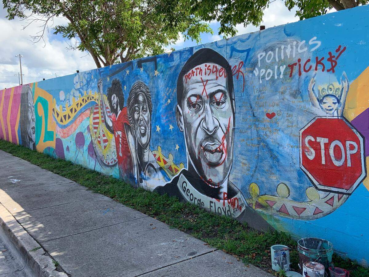 The vandalized Kyle Holbrook mural of George Floyd as Holbrook starts repair work on it Thursday morning.