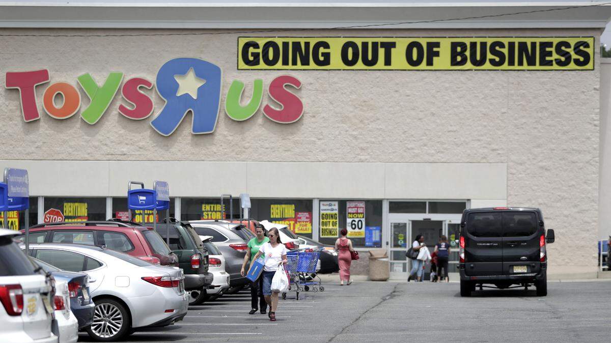 FILE - In this Friday, June 1, 2018 file photo, customers walk back to their vehicles after shopping at a Toys R Us store in Totowa, N.J.