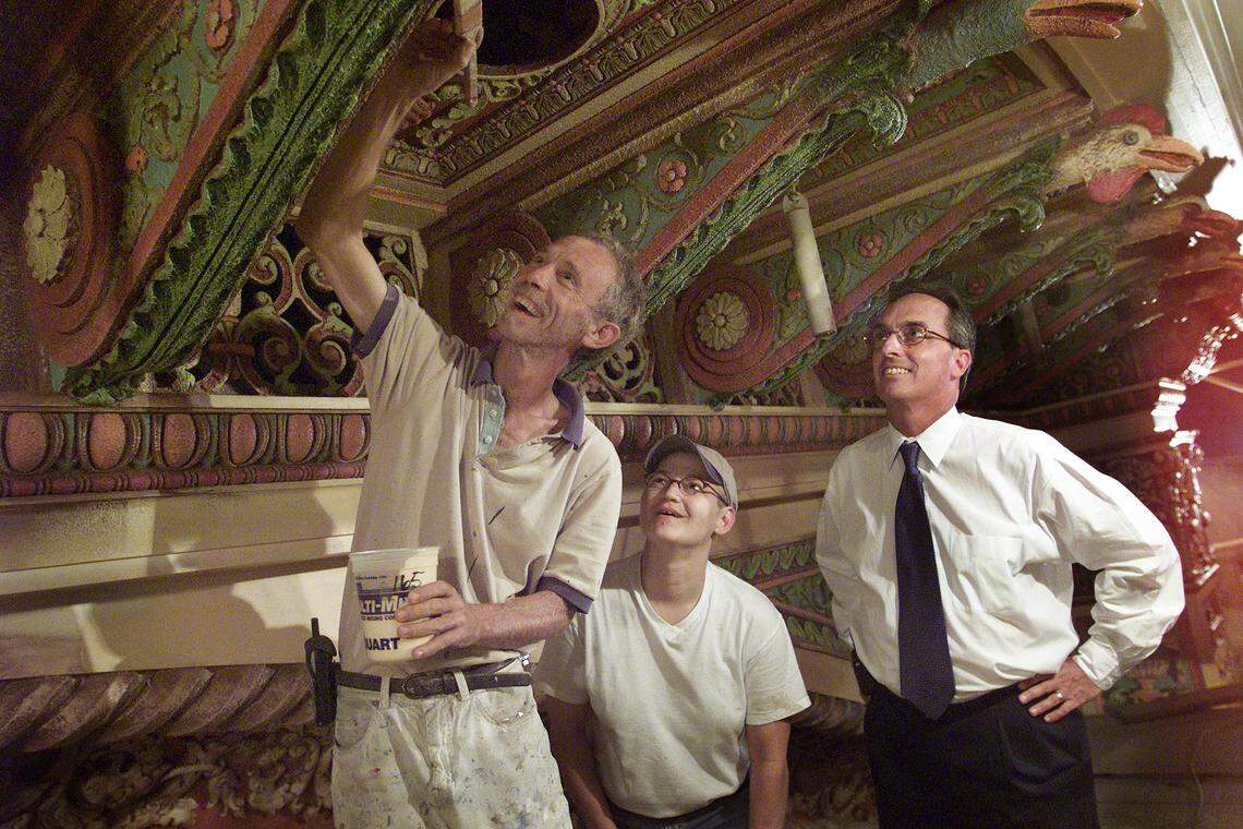 July 31, 2002 – Jarrett Ellis of Evergreen Studios carefully applies layers of paint by hand as part of the meticulous restoration of the Gusman Theater’s original color scheme and intricate details. Looking on are Sherry Thomas, also with Evergreen, and Richard Heisenbottle, the lead restoration architect.