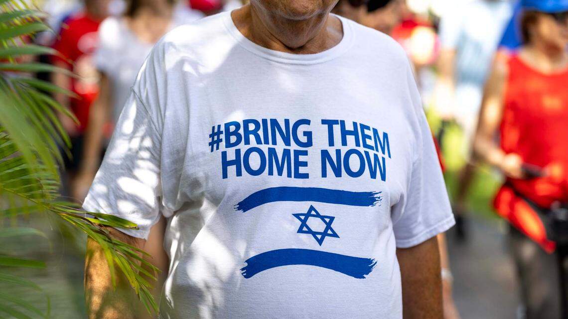A demonstrator sports a shirt that reads “#BRING THEM HOME NOW” during a solidarity walk hosted by “Run for Their Lives” at Aventura Circle on Sunday, June 8, 2025.