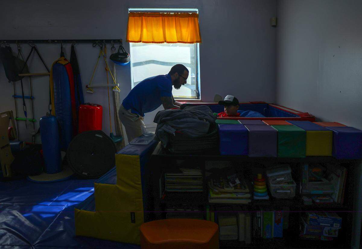 Occupational therapist David Balleti, engages with Ethan Morejon, 7, during therapy session in the occupation therapy gym. The Miami Herald was given tour of the school as it tries to continue to serve the needs of children with autistic students on Monday, September 23, 2025.