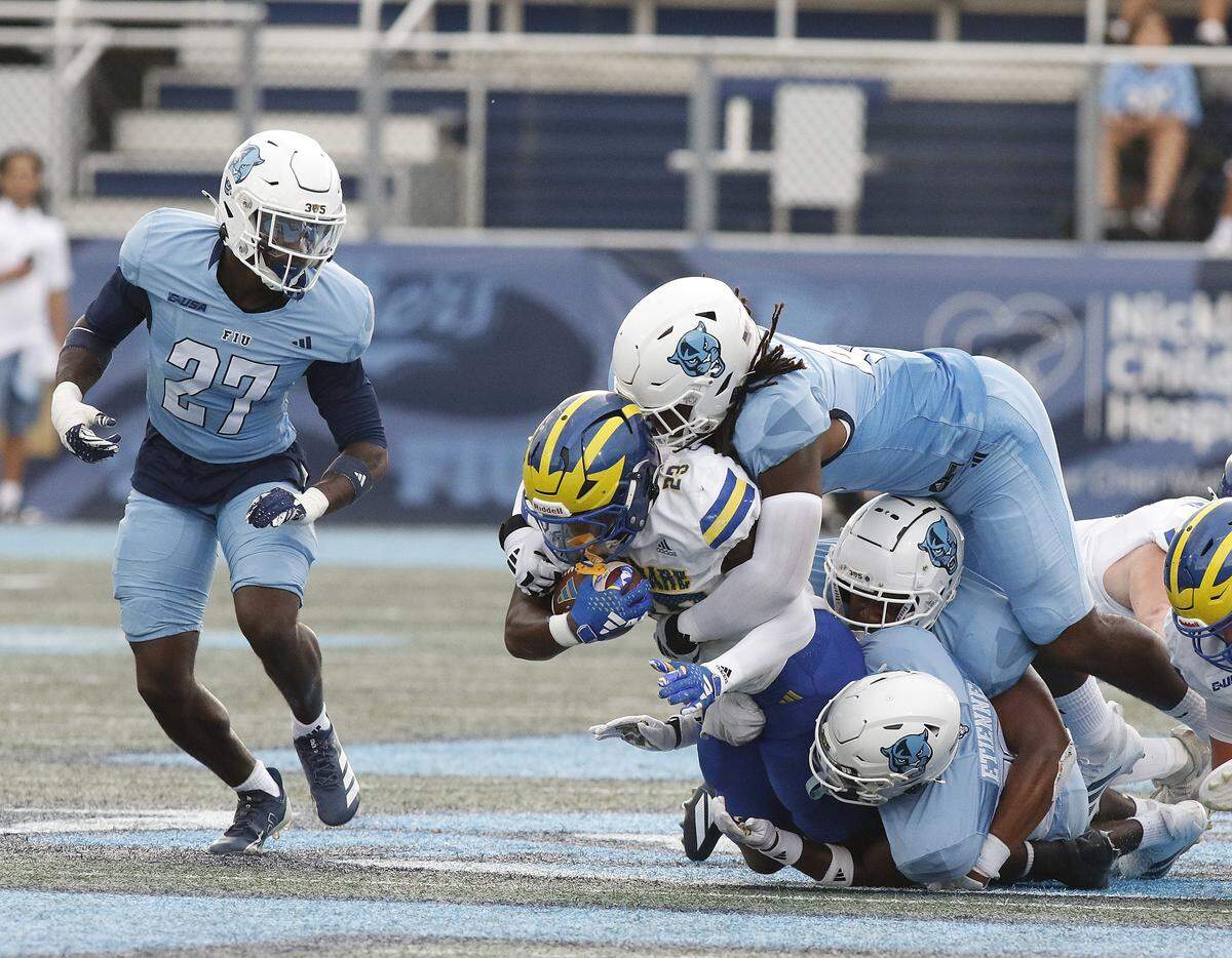 FIU Panthers defenders tackle Delaware Fightin' Blue Hens running back Viron Ellison Jr. (23) during football game on Saturday, September 20, 2025 at FIU Pitbull Stadium in Miami.  Andrew Uloza / for Miami Herald
