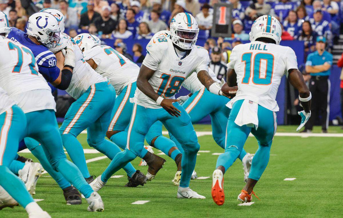 Miami Dolphins quarterback Tyler Huntley (18) hands off to Miami Dolphins wide receiver Tyreek Hill (10) in the first half against the Indianapolis Colts during an NFL football game in Indianapolis, Indiana on Sunday, October 20, 2024. 