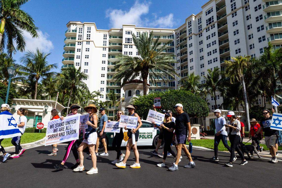 Demonstrator walk past a condominium during a solidarity “Run for Their Lives” walk to raise awareness for the 58 hostages still held in Gaza at Aventura Circle on Sunday, June 8, 2025, in Aventura, Fla.