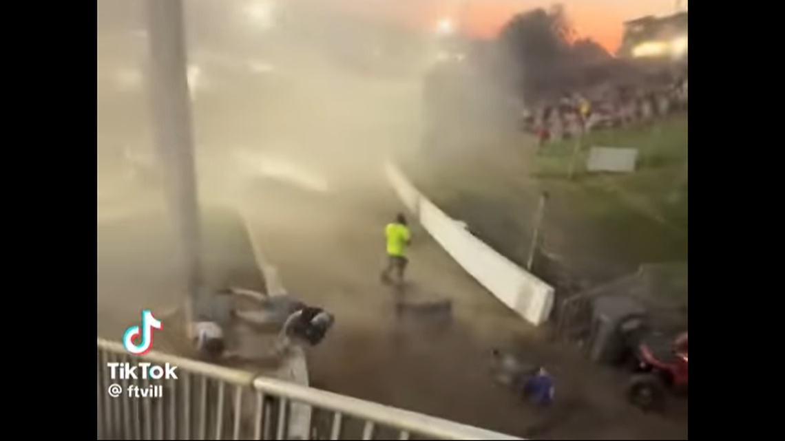 This video screenshot shows the moment two fans (at the left) began tumbling over a wall and a third (lower right) landed on the concrete.