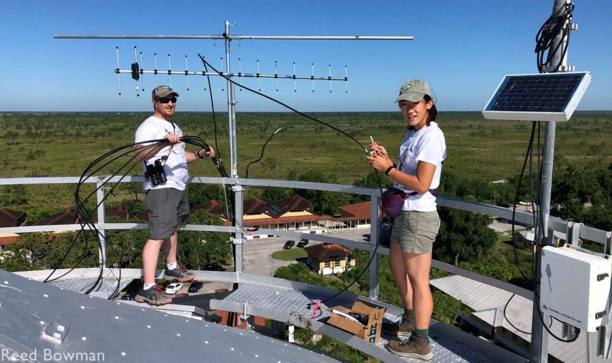 Young Ha Suh, right, and Michael Lazone, head of Cellular Tracking Technologies, work on assembling the antenna on the system’s base station on top of a water tower.
