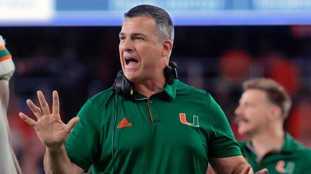Miami Hurricanes head coach Mario Cristobal speaks with players during a timeout in the first half during the NCAA football game against Syracuse Orange in the JMA Wireless Dome at Syracuse University, Syracuse, New York on Saturday, November 30, 2024.