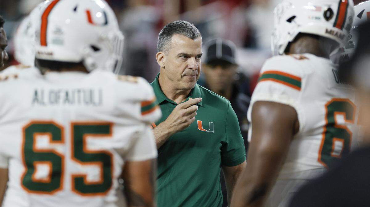 Miami Hurricanes head coach Mario Cristobal talks with players in the first half of the College Football Playoff National Championship Game against the Indiana Hoosiers at Hard Rock Stadium in Miami Gardens, Florida, on Monday, January 19, 2026.