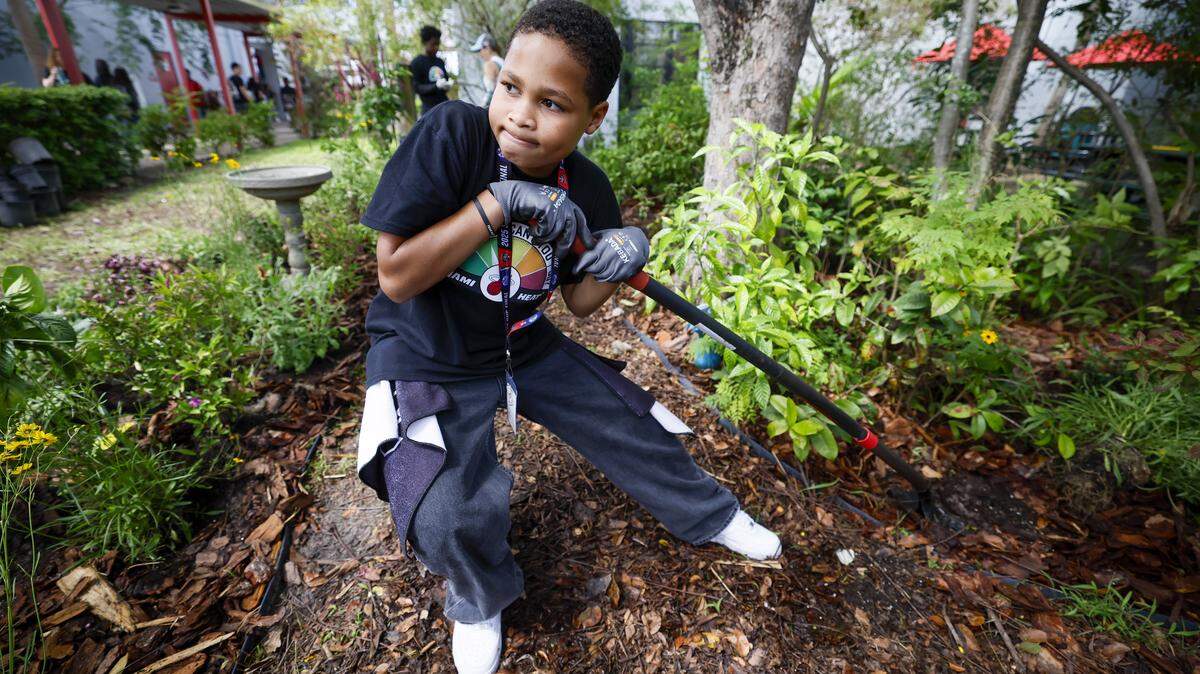 Student Tanner English digs a hole in the garden as the school prepares for Earth Day, as the Miami Heat transforms the outdoor area at Driftwood Middle School by installing a new garden and updating the interior. Featuring a butterfly garden, planting beds, and indoor hydroponic towers, students help by planting flowers, vegetables, and greenery, creating a welcoming and peaceful environment in Hollywood, Florida, on Thursday, April 9, 2026. 