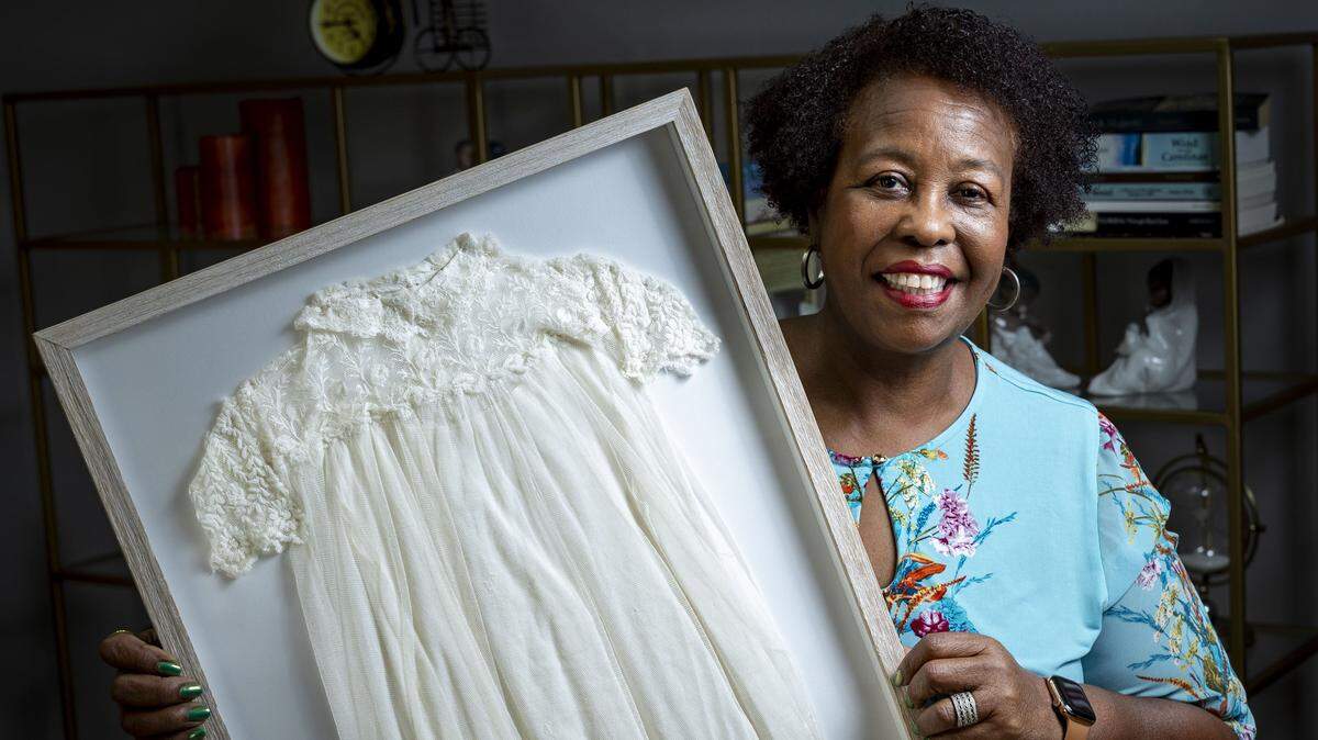 Miami Gardens, FL, October 21, 2025 - Patricia Braynon, whose family has been in the U.S. since the 1800s, shows off a Baptismal gown that has been in her family since the 1890's