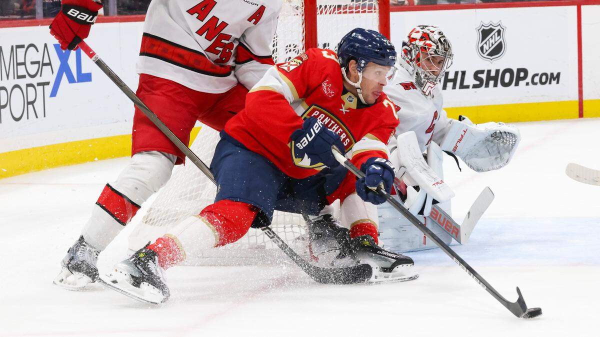 Florida Panthers center Carter Verhaeghe (23) keeps the puck from Carolina Hurricanes defenseman Jaccob Slavin (74) and goaltender Pyotr Kochetkov (52) during the second period of a game on Thursday, Jan. 2, 2025, at Amerant Bank Arena in Sunrise, Fla.