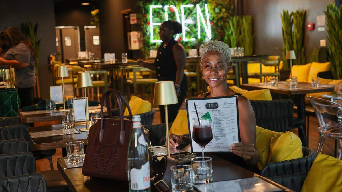 Sasha Pusey, 40, skims over the menu while waiting for the arrival of her boyfriend at the Broward African restaurant Eden on Wednesday, Sept. 10, 2025, in West Park, Florida.