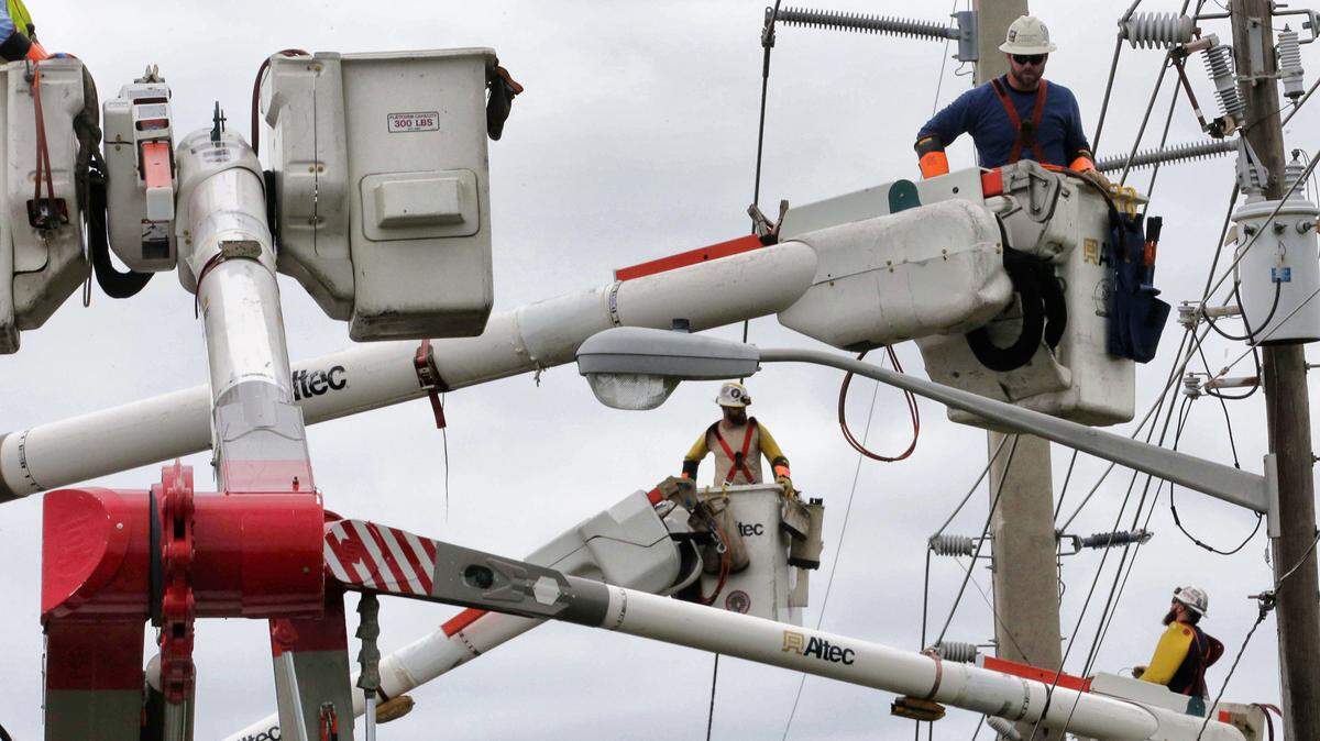 Workers from Jersey Central Power & Light repair high-voltage power lines downed by Hurricane Matthew, along Beville Road in Daytona Beach, Monday, Oct. 10, 2016.