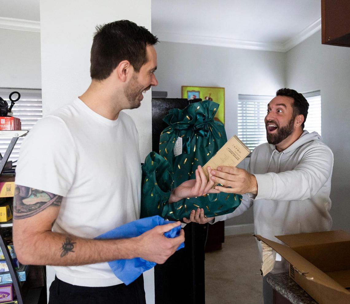David Zarco, 36, left, and his friend Mike Cotugno, 36, react to a gift sent to Zarco’s home by a social media follower.