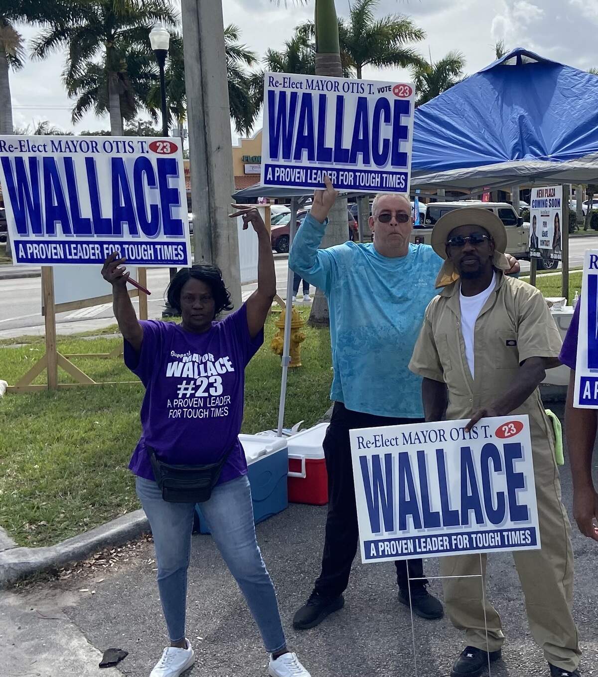 Pamela Davis, Robert Calero and Victor Butler, who are supporters of Florida City Mayor Otis Wallace, hold his campaign signs outside of City Hall Tuesday, Feb. 15, 2022.