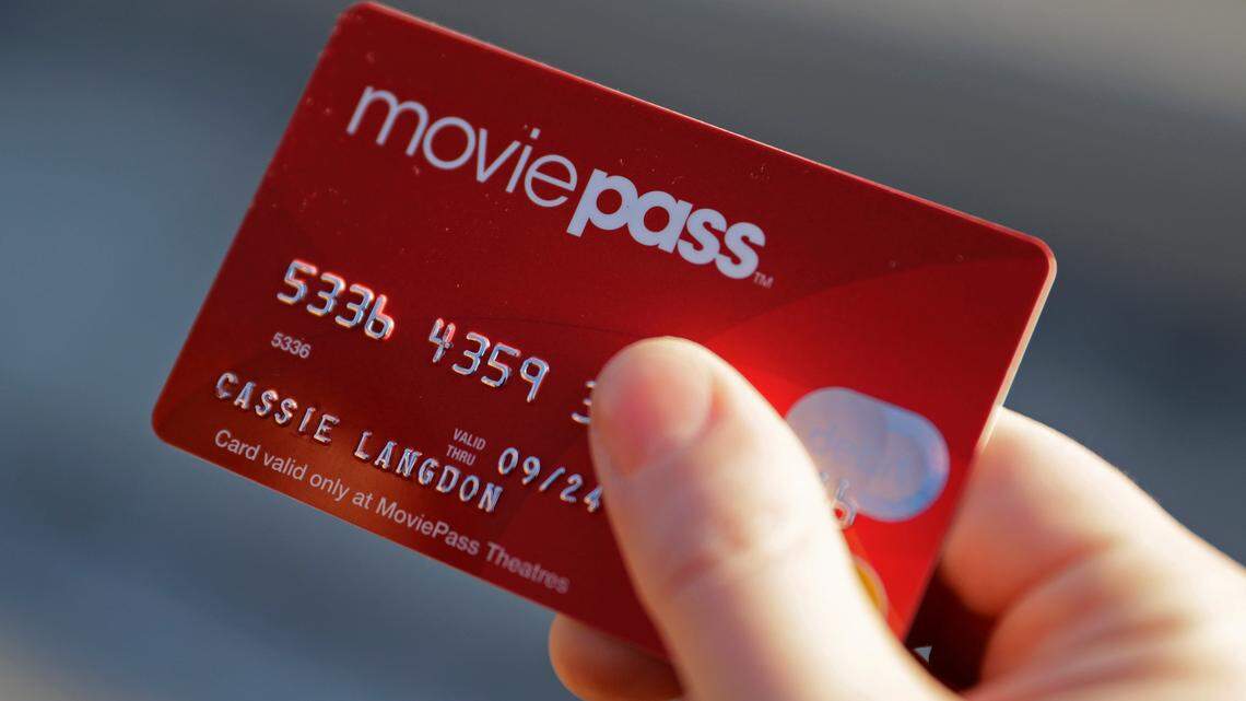 In this Jan. 30, 2018, file photo, Cassie Langdon holds her MoviePass card outside AMC Indianapolis 17 theater in Indianapolis.  The startup that lets customers watch a movie a day at theaters for just $10 a month is limiting new customers to just four movies a month. The move comes as customers and industry experts question the sustainability of MoviePass’ business model. Because MoviePass is paying most theaters the full price of the ticket, the service is in the red with just one or two movies in a month.