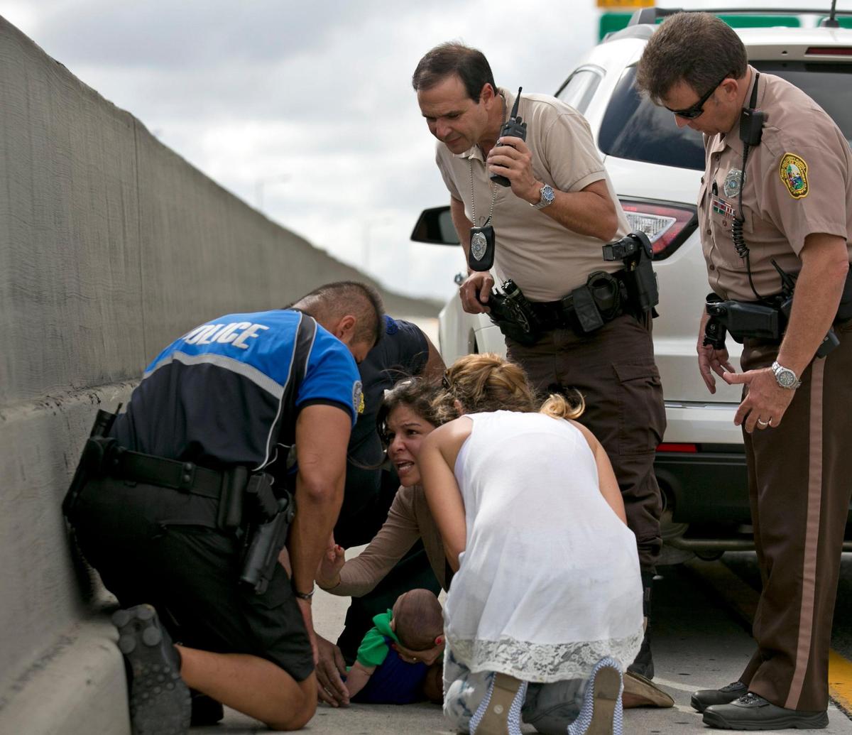 Rescuers with Pamela Rauseo at the center, who performed CPR on her nephew, 5-month-old Sebastian de la Cruz, after pulling her SUV over on the side of the road along the westbound lane on Florida State Road 836 just east of 57th Avenue around 2:30 p.m. on February 20, 2014. At right is Lucila Godoy who stopped her car to assist in the rescue. At left is Sweetwater police officer Amauris Bastidas who was passing by and stopped to help.