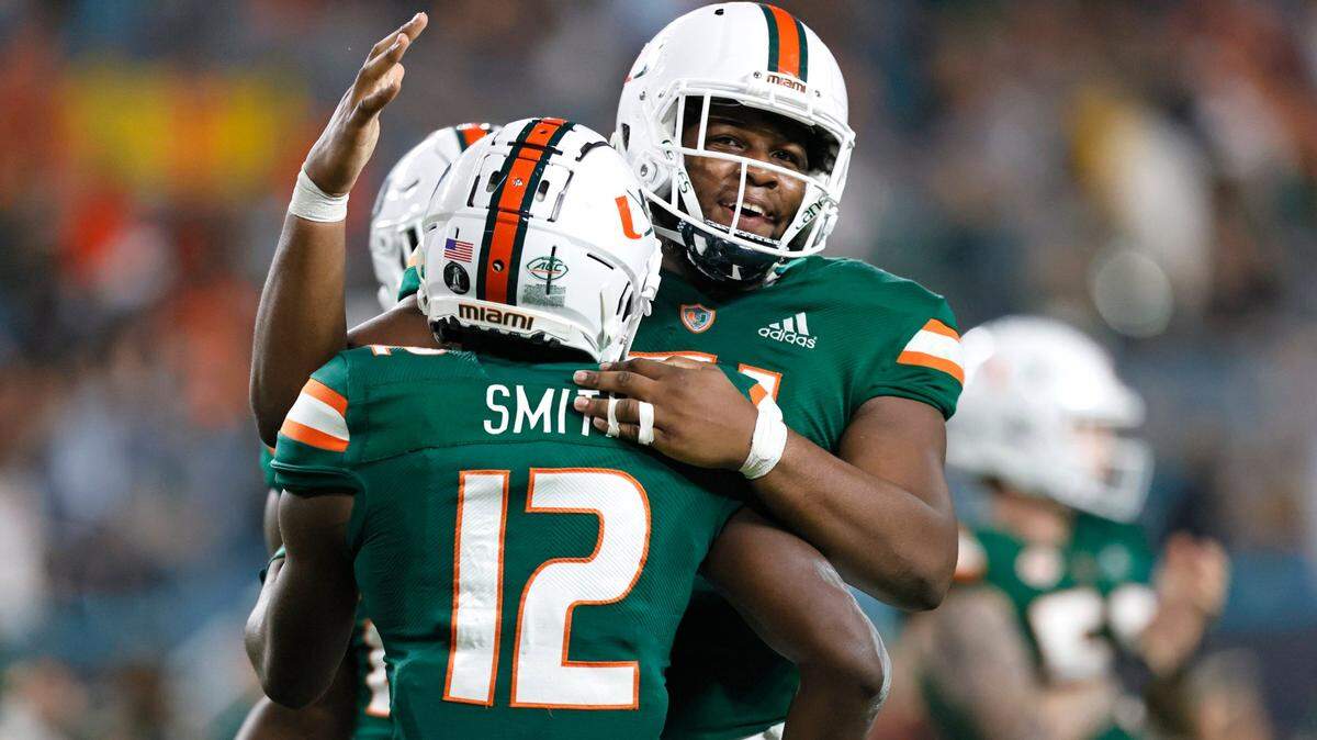 Miami Hurricanes wide receiver Brashard Smith (12) is congratulated by Hurricanes offensive lineman DJ Scaife Jr. (51) after scoring a touchdown against Virginia Tech Hokies during the second quarter of their ACC football game at Hard Rock Stadium on Saturday, November 20, 2021 in Miami Gardens, Florida.