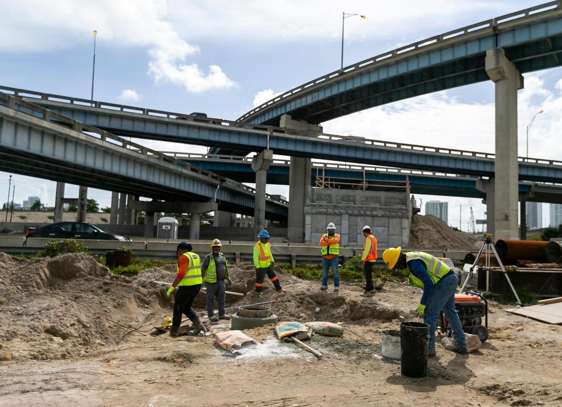 Construction employees work to install a new manhole at the core of the I-395, SR-836 and I-95 construction project taking place near downtown Miami and Overtown on Tuesday, June 8, 2021.