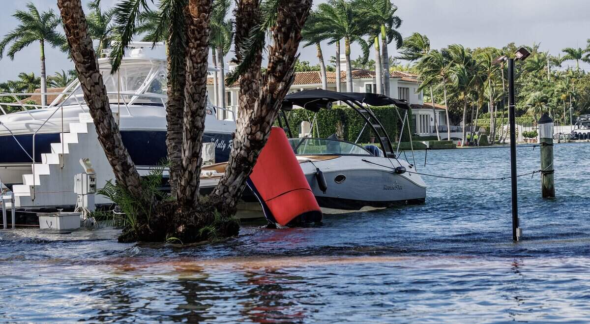 Vessels docked on Collins Avenue and 50th Street rising up to street level during king tide in Miami Beach.