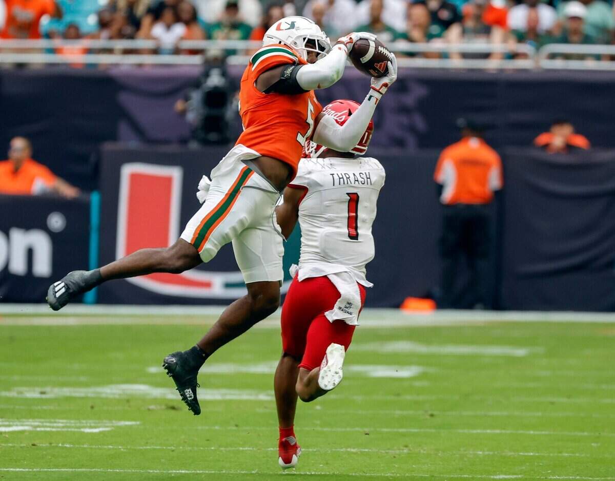 Miami Hurricanes safety Kamren Kinchens (5) intercepts a pass intended for Louisville Cardinals wide receiver Jamari Thrash (1) in the first quarter on Saturday, November 18, 2023.
