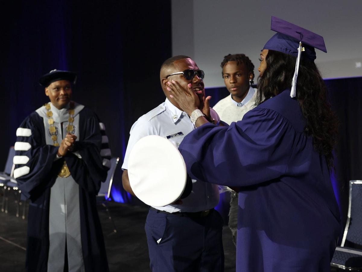 Jennifer Freeman, 54, holds her son, Marcus Roberts, U.S. Coast Guardsman, after he surprises her before her graduation from Broward College at the Broward County Convention Center in Fort Lauderdale on Thursday, May 5, 2022. Roberts was stationed in Malta and was not going to be able to see his mother graduate. When he found out his deployment was shortened, he surprised her. “It was a family affair; we all worked together to make my degree happen,” said Freeman.