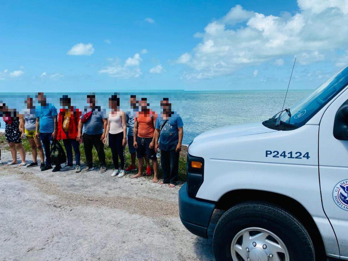 A group of people who migrated from Cuba stand on the shore of Long Key State Park Friday, March 18, 2022.