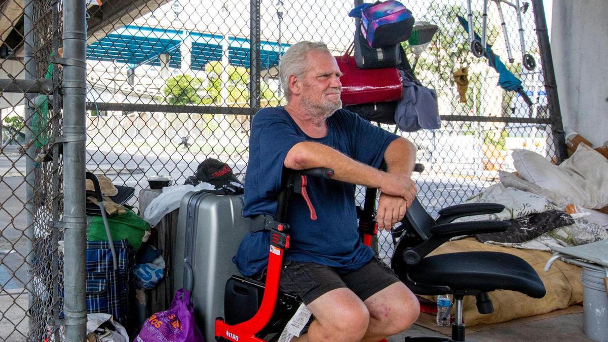 Houseless person Jeffrey Snow, a former Booker T. Washington math teacher, sits underneath Interstate 95 in Miami on Sept. 20.