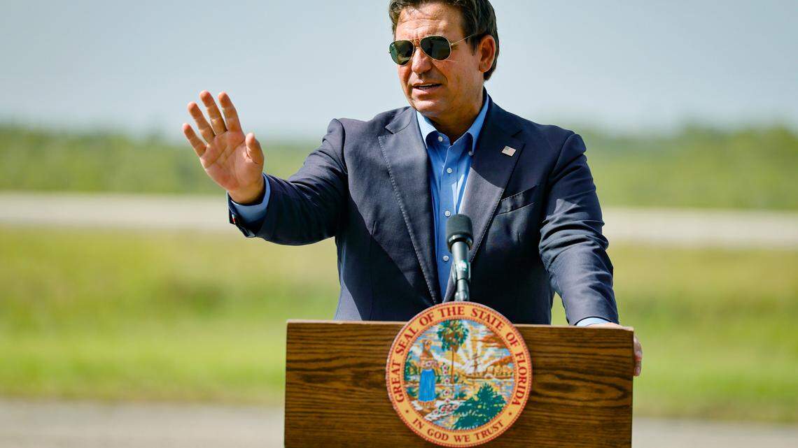 Gov. Ron DeSantis speaks to reporters during a press conference as he stands on the airplane runway of Alligator Alcatraz in Ochopee on July 25, 2025. 