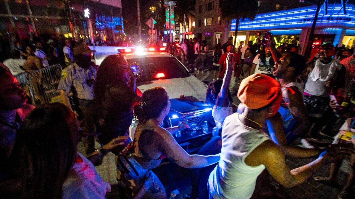 A woman twerks on the hood of a Miami-Dade police cruiser on Ocean Drive after curfew during Spring Break in 2021.