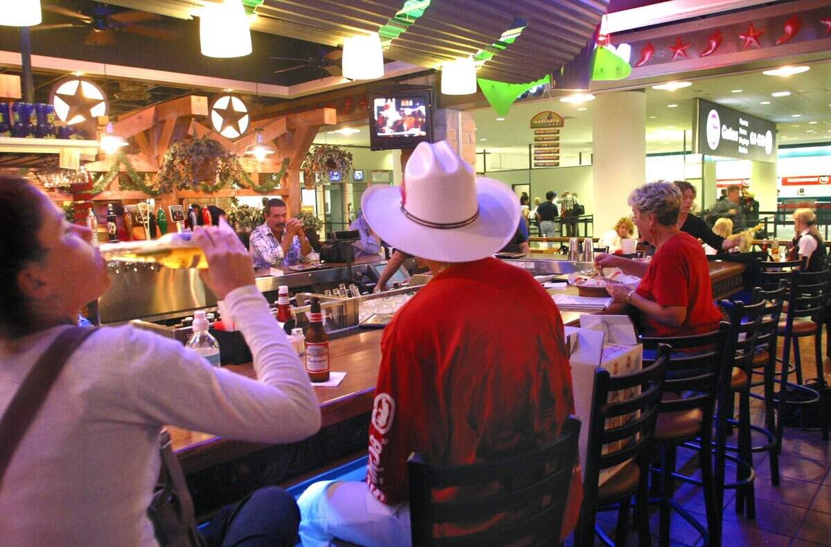 In 2002, travelers stop for a beer at the bar in Chilis Too in Terminal G.