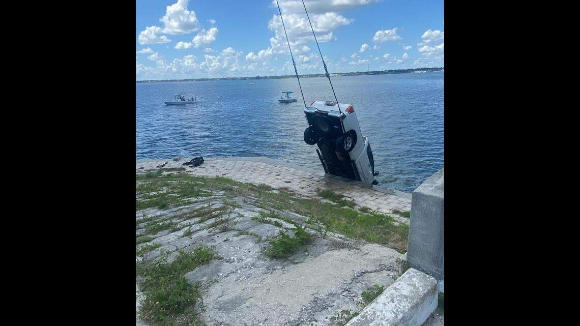 This photo shows the truck being pulled from the water. A driver trapped inside was kept alive when two good Samaritans held his head above water, according to Florida investigators.