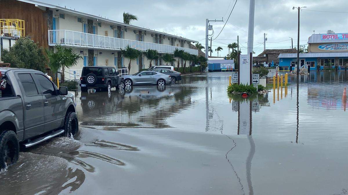 A pickup truck drives through saltwater storm surge in the parking lot of Gilbert’s Resort on the bay side of Key Largo Thursday, Nov. 16, 2023.